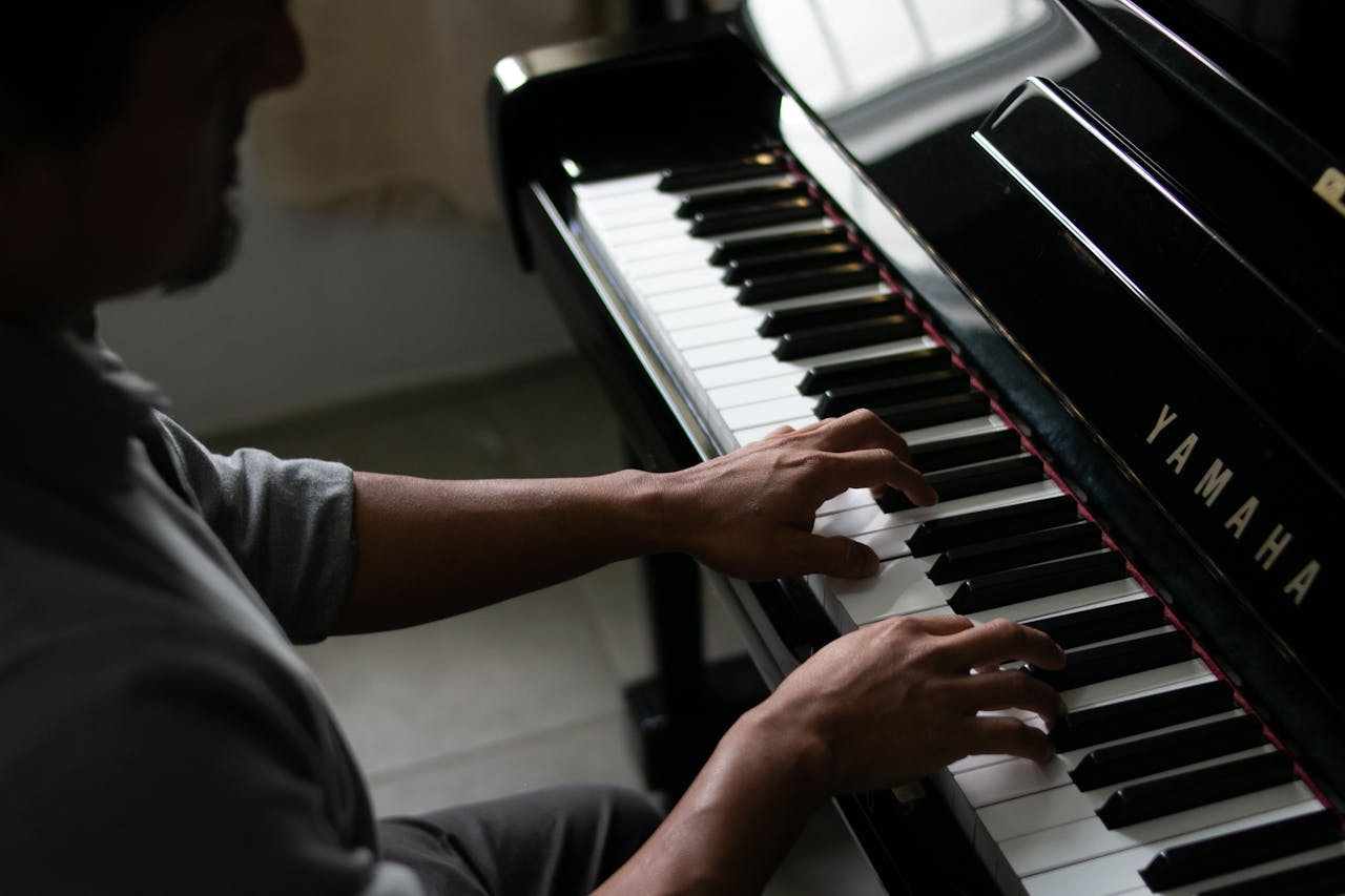 Artistic close-up of a musician's hands playing a Yamaha piano. Captures musical elegance.